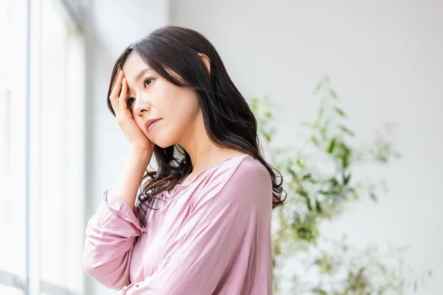 悩んで手を抱える女性