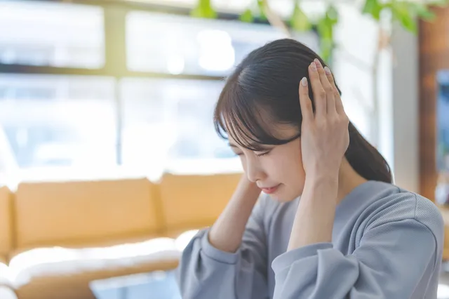 騒音に耳を塞ぐ女性